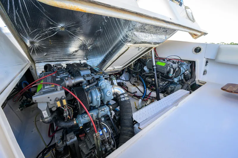 Slide: The Image of Engine compartment of 1998 Aura 28 Tournament Series boat, showcasing dual engines and wiring. - 37