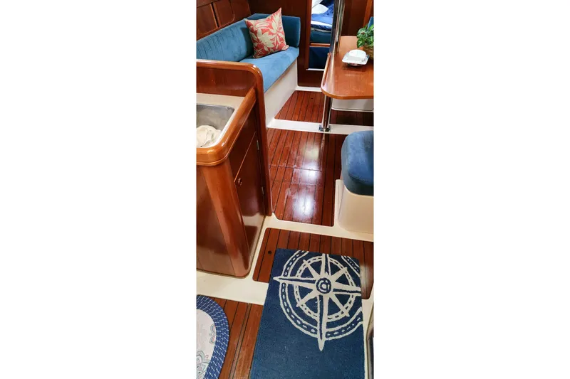 Slide: The Image of Interior of 1999 Beneteau Oceanis 321 sailboat with wooden flooring and blue seating. - 13