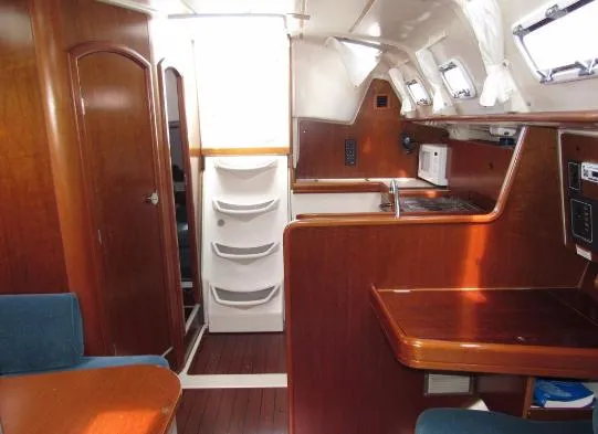 Slide: The Image of Interior of a 1999 Beneteau Oceanis 321 yacht, featuring wood furnishings and kitchen. - 16