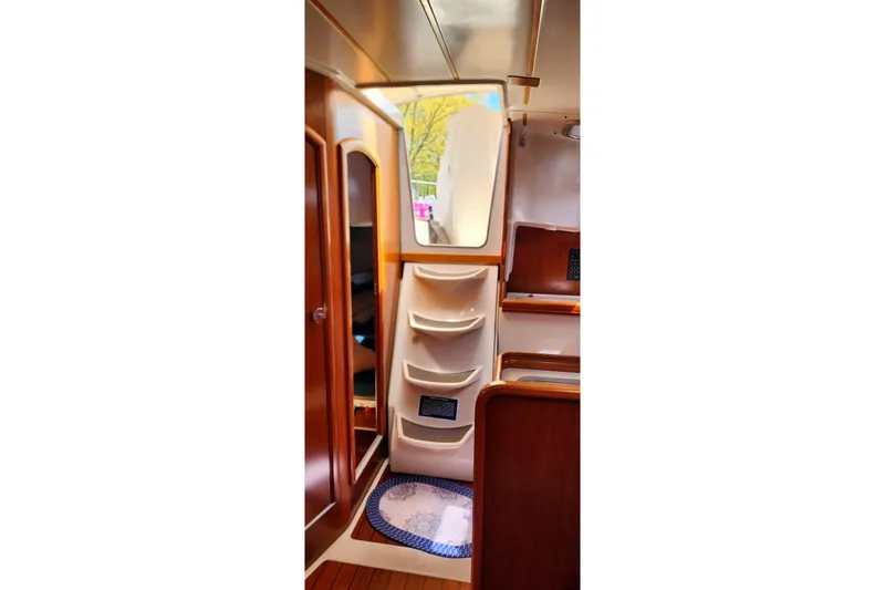 Slide: The Image of Interior of 1999 Beneteau Oceanis 321 sailboat, featuring wooden cabinetry and compact storage. - 17
