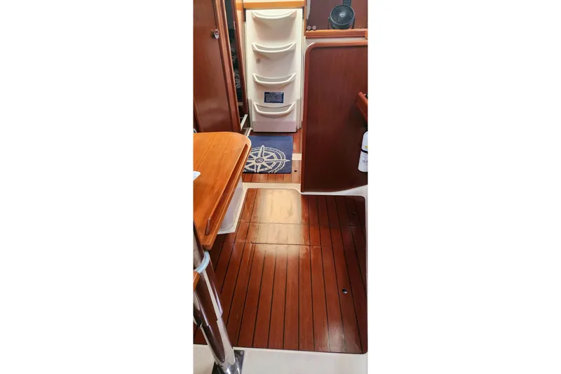 Slide: The Image of Interior of 1999 Beneteau Oceanis 321 sailboat with wooden flooring and storage compartments. - 18