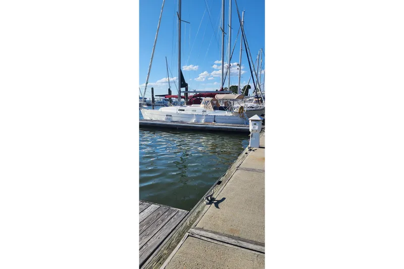 Slide: The Image of 1999 Beneteau Oceanis 321 sailboat docked at marina under clear blue sky. - 2
