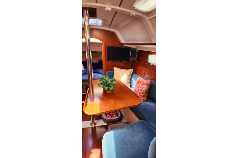 Slide: The Image of Interior of 1999 Beneteau Oceanis 321 sailboat with cozy seating and wooden table. - 20