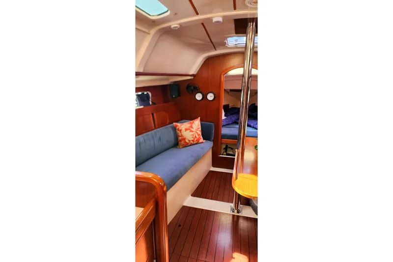 Slide: The Image of Interior of 1999 Beneteau Oceanis 321 sailboat with cozy seating and wooden finishes. - 21