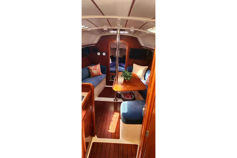Slide: The Image of Interior of 1999 Beneteau Oceanis 321 sailboat with cozy seating and wooden finishes. - 23