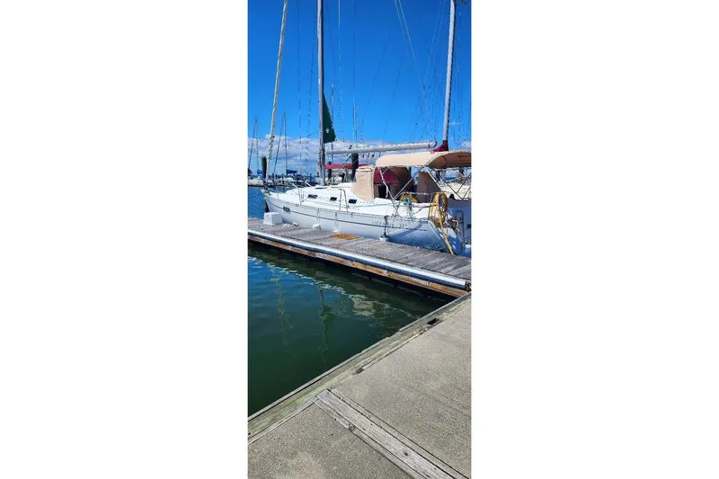 Slide: The Image of 1999 Beneteau Oceanis 321 sailboat docked at marina under clear blue sky. - 3