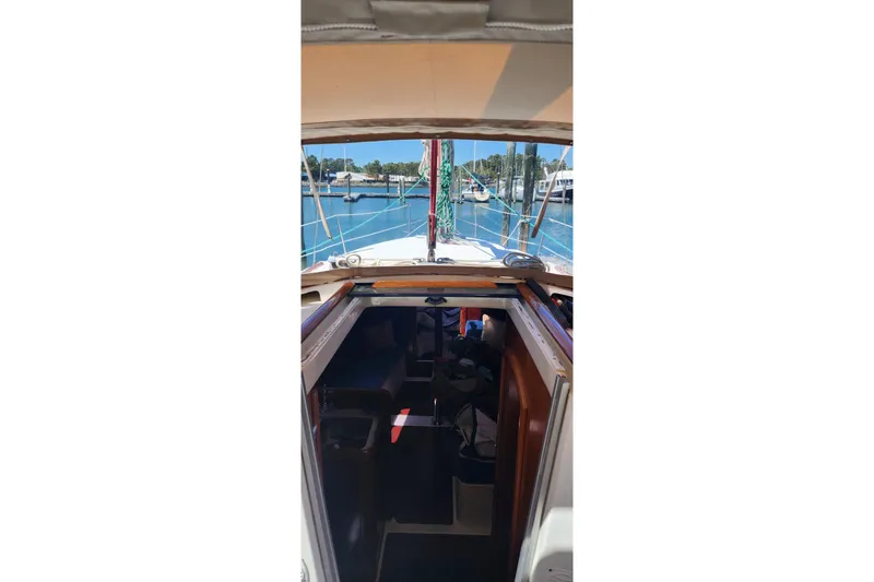 Slide: The Image of 1999 Beneteau Oceanis 321 sailboat interior view with marina background. - 9