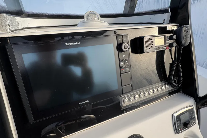 Slide: The Image of 2017 Tidewater 230 CC Adventure boat dashboard with Raymarine display and marine radio. - 4
