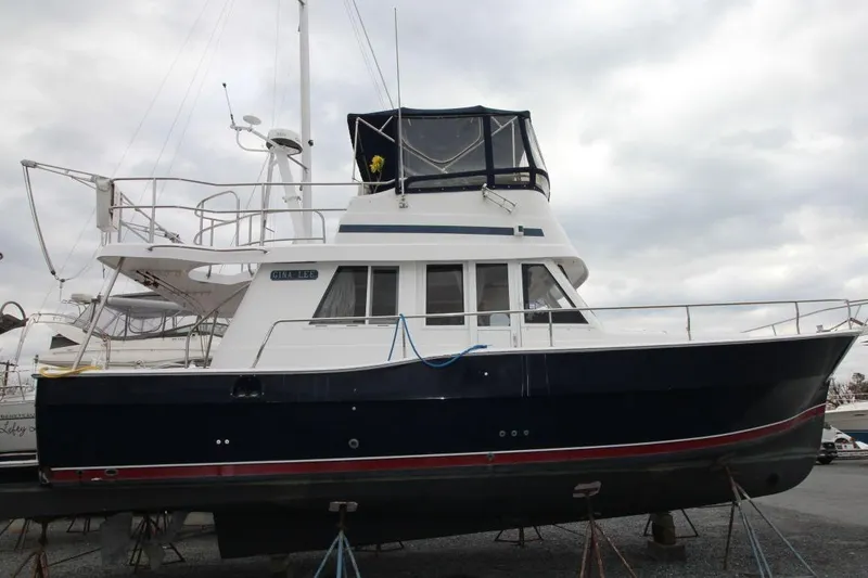 Slide: The Image of 2002 Mainship 390 Trawler deck with stairs, teak flooring, and marina view. - 11
