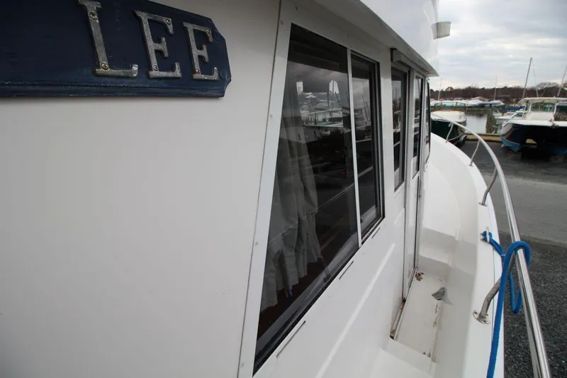 Slide: The Image of 2002 Mainship 390 Trawler flybridge with seating and helm, docked at marina. - 15