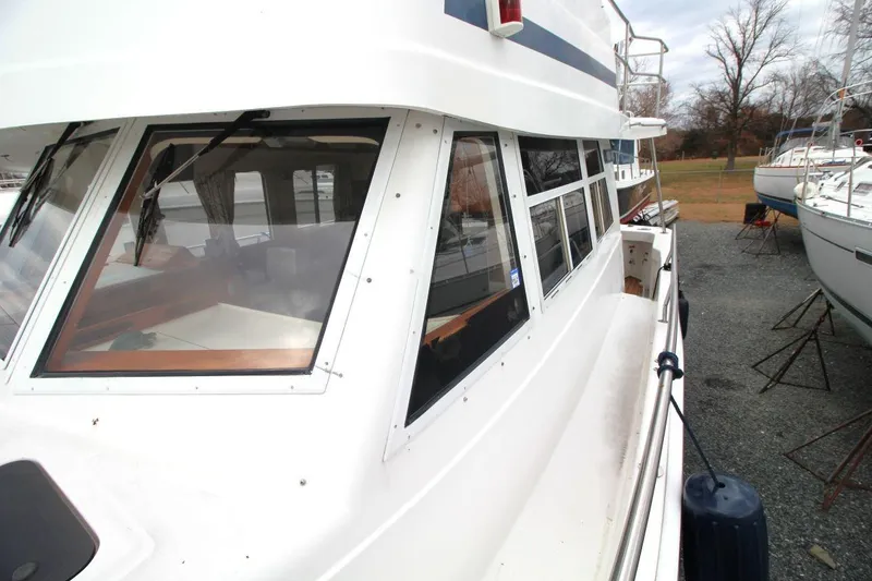 Slide: The Image of 2002 Mainship 390 Trawler deck view at marina, showcasing sleek design and spacious layout. - 19