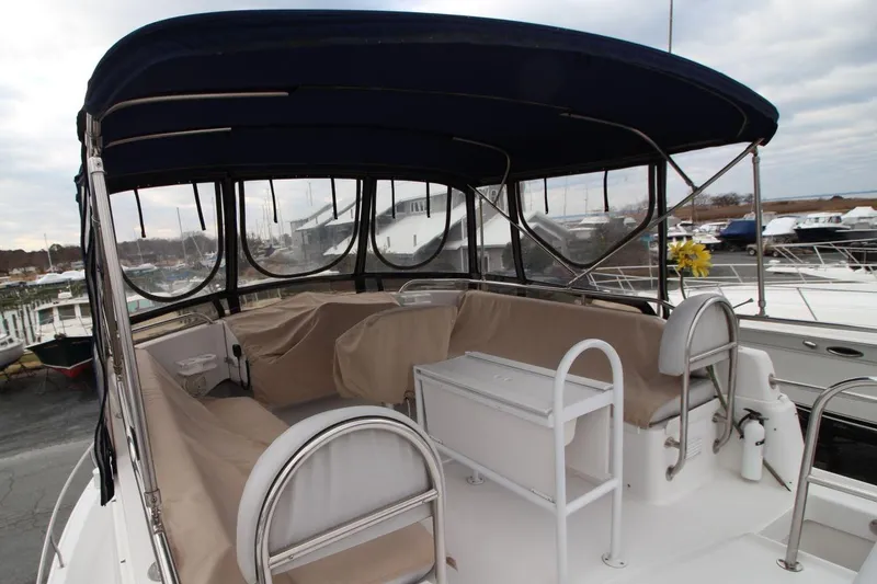 Slide: The Image of 2002 Mainship 390 Trawler, white exterior, docked among other boats. - 21