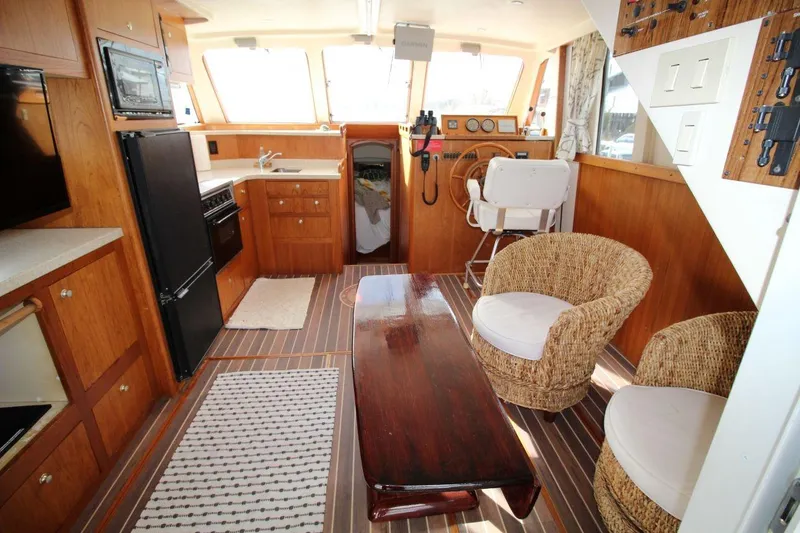 Slide: The Image of 2002 Mainship 390 Trawler helm with Garmin navigation, wooden wheel, and captain's chair. - 28