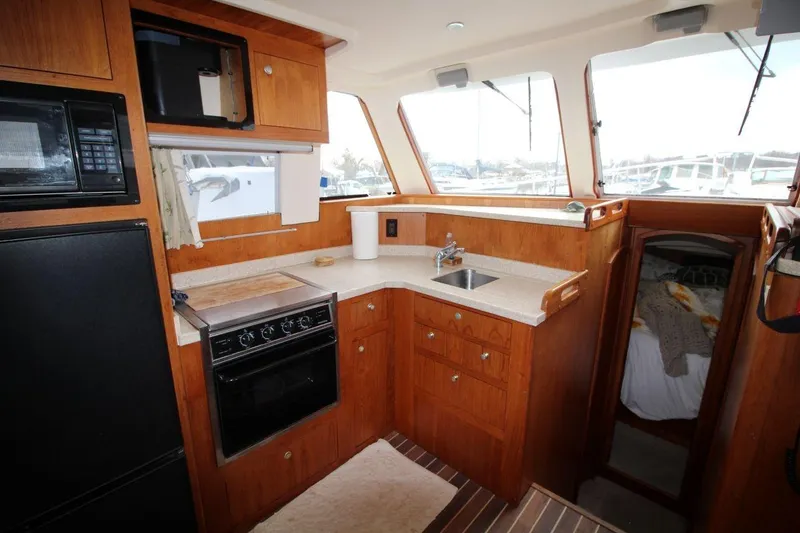 Slide: The Image of Interior of 2002 Mainship 390 Trawler with wicker chairs and sliding glass door. - 29