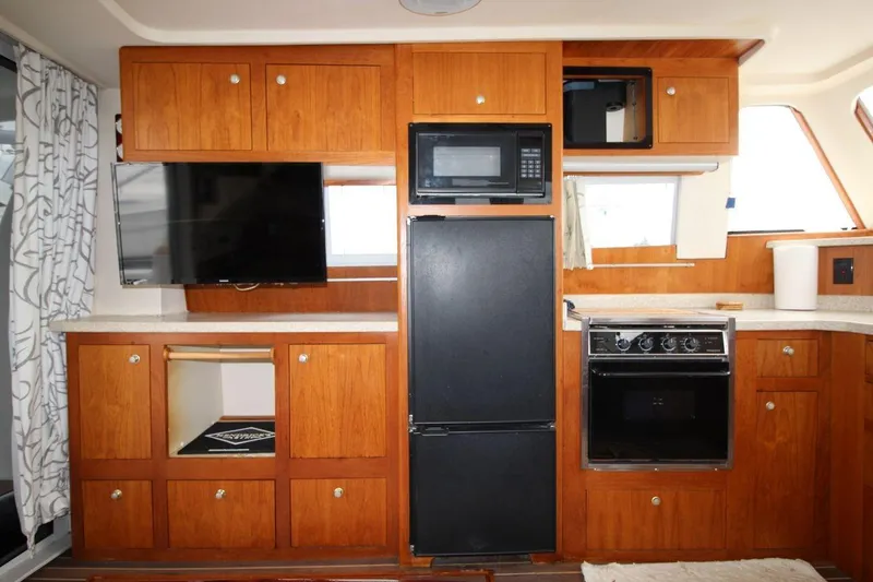 Slide: The Image of Cozy cabin interior of 2002 Mainship 390 Trawler with plush bedding and wooden cabinets. - 30