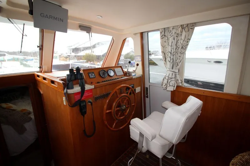 Slide: The Image of 2002 Mainship 390 Trawler cabin with wooden cabinetry and cozy bedding. - 31