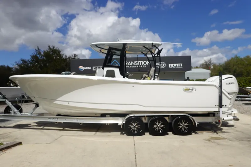 The Image of 2026 Sea Hunt Gamefish 28 Forward Seating boat on trailer under blue sky. - 2
