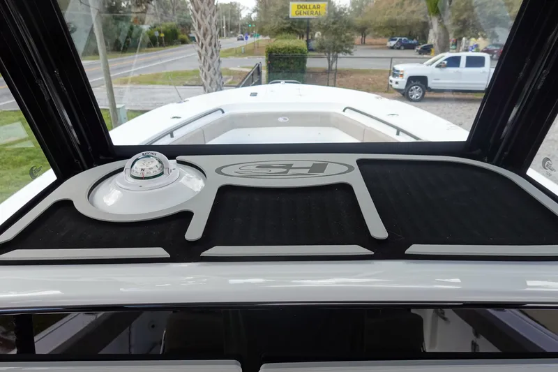 Slide: The Image of 2026 Sea Hunt Gamefish 28 Forward Seating boat dashboard with compass and logo. - 24