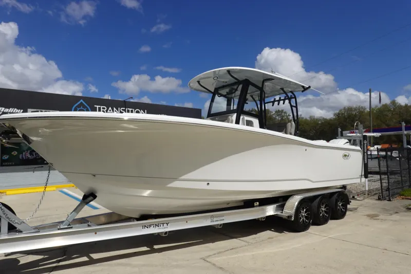 Slide: The Image of 2026 Sea Hunt Gamefish 28 Forward Seating boat on trailer under blue sky. - 3