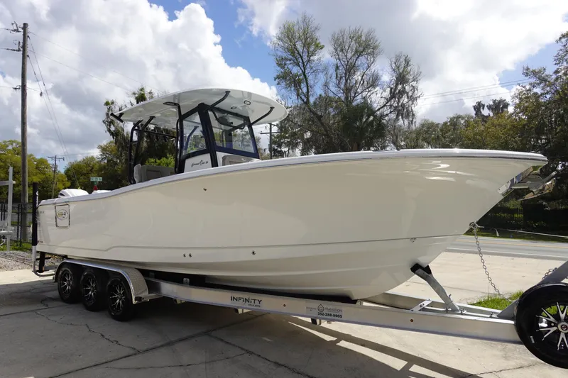 Slide: The Image of 2026 Sea Hunt Gamefish 28 Forward Seating boat on trailer, parked outdoors. - 4