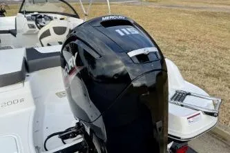 Slide: The Image of 2022 Tahoe 200 S boat on trailer, parked outdoors with flags in the background. - 10