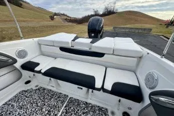 Slide: The Image of 2022 Tahoe 200 S boat on trailer, parked outdoors with flags in the background. - 15