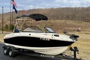 Slide: The Image of 2022 Tahoe 200 S boat interior with cushioned seating and scenic outdoor backdrop. - 2