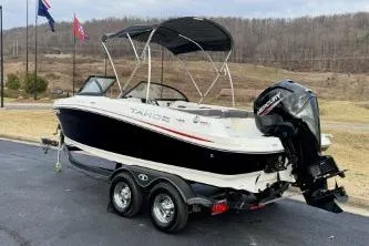 Slide: The Image of 2022 Tahoe 200 S boat with outboard motor on a trailer, parked outdoors. - 20