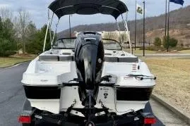 Slide: The Image of 2022 Tahoe 200 S boat with outboard motor, parked on a trailer, scenic background. - 22