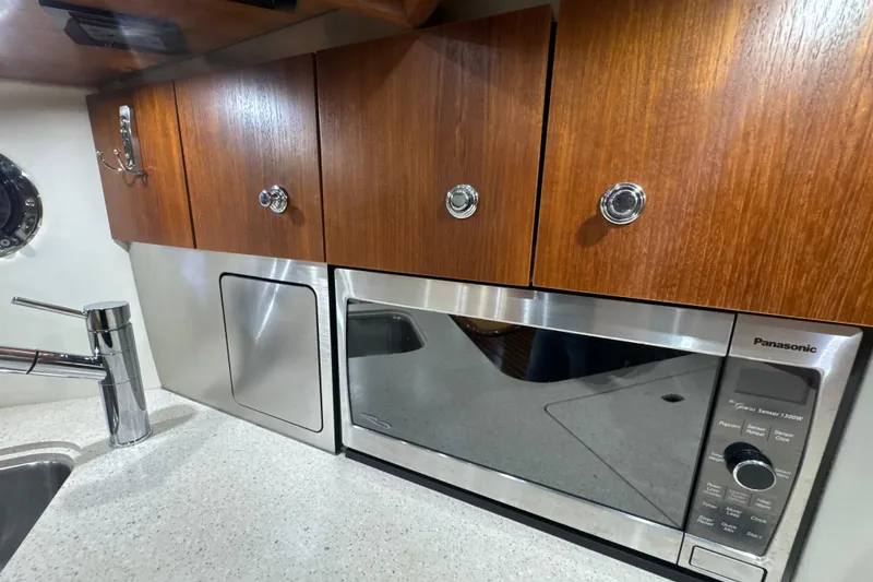 Slide: The Image of 2006 Tiara Yachts 3600 Sovran galley with wooden cabinets and stainless steel appliances. - 15