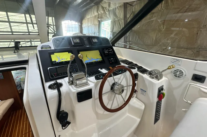 Slide: The Image of Helm of 2006 Tiara Yachts 3600 Sovran with navigation screens and wooden steering wheel. - 39