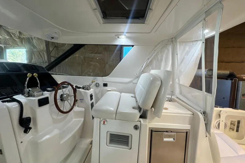 Slide: The Image of 2006 Tiara Yachts 3600 Sovran helm with white seating and wooden steering wheel. - 44