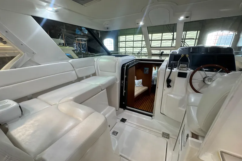 Slide: The Image of 2006 Tiara Yachts 3600 Sovran interior with white seating and wooden steering wheel. - 49
