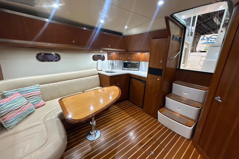 Slide: The Image of 2006 Tiara Yachts 3600 Sovran interior with wood finish, kitchenette, and seating area. - 6