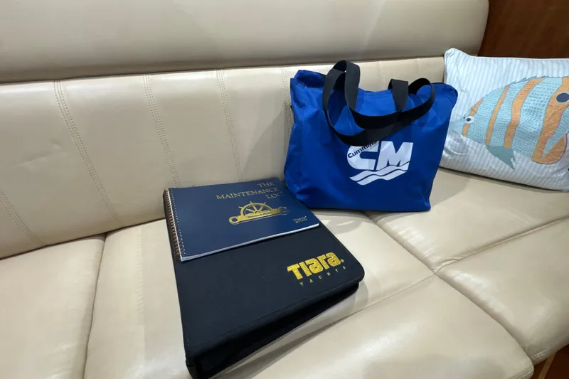 Slide: The Image of 2006 Tiara Yachts 3600 Sovran maintenance log and bag on beige leather seat. - 65