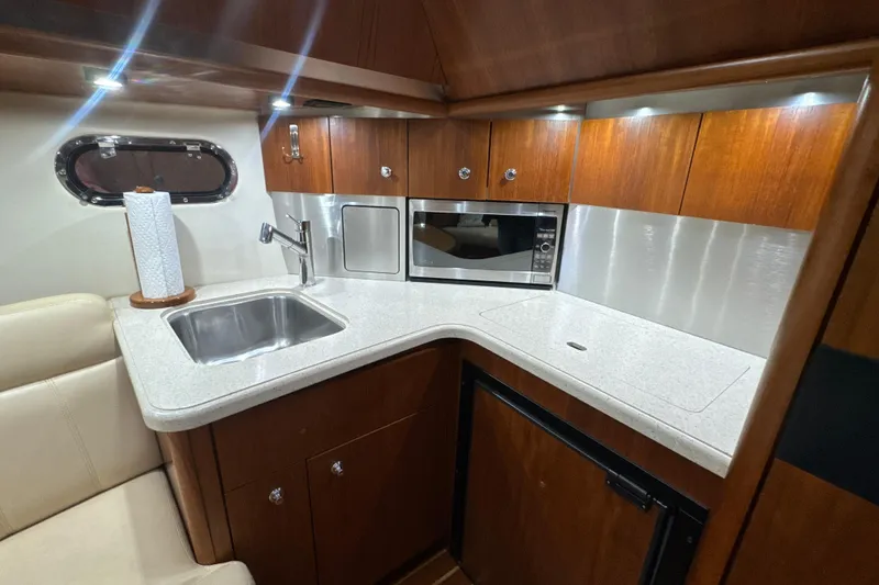 Slide: The Image of 2006 Tiara Yachts 3600 Sovran galley with sink, microwave, and wood cabinetry. - 8