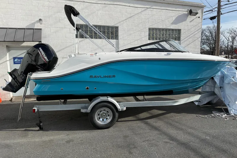 Slide: The Image of 2026 Bayliner V20 boat on trailer, blue hull, Mercury outboard motor. - 2