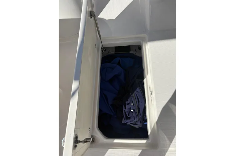 Slide: The Image of Storage compartment on a 2020 Robalo R227 Dual Console boat with blue fabric inside. - 8
