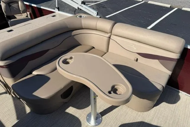 Slide: The Image of 2019 Bennington 20 SFX boat interior with beige seating and table, featuring cup holders. - 12