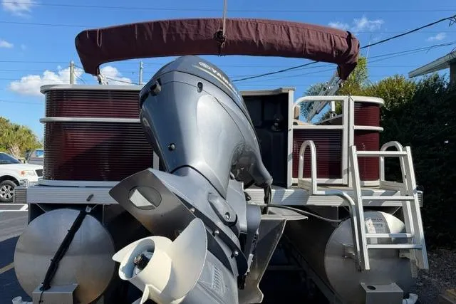 Slide: The Image of 2019 Bennington 20 SFX pontoon boat with outboard motor, parked outdoors. - 6