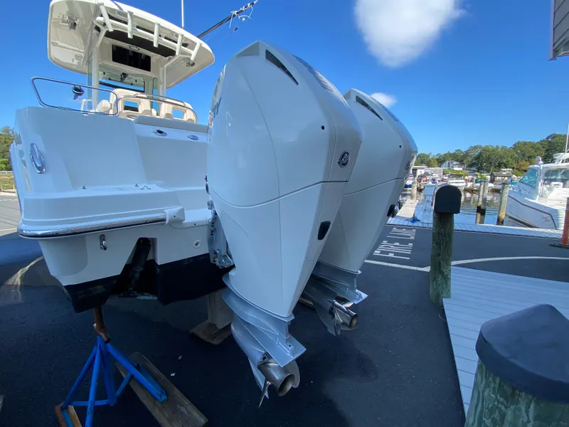 Slide: The Image of 2020 Boston Whaler 250 Outrage with twin outboard engines at the dock. - 9
