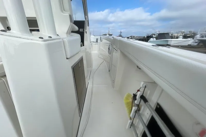 Slide: The Image of 2021 Pursuit S 328 Sport boat deck with white seating and storage compartments. - 16