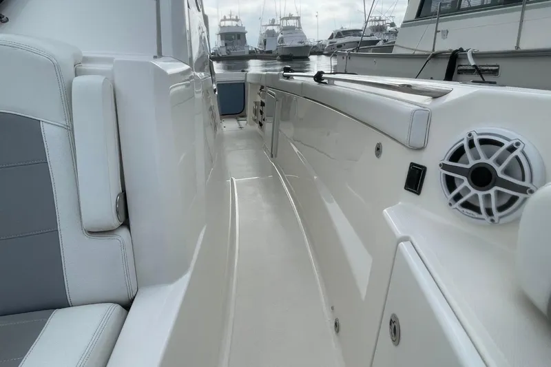Slide: The Image of 2021 Pursuit S 328 Sport boat interior with seating and speaker, docked at marina. - 17