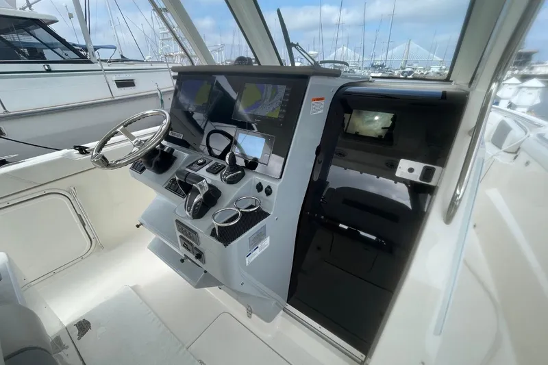 Slide: The Image of 2021 Pursuit S 328 Sport boat helm with advanced navigation displays and controls. - 19