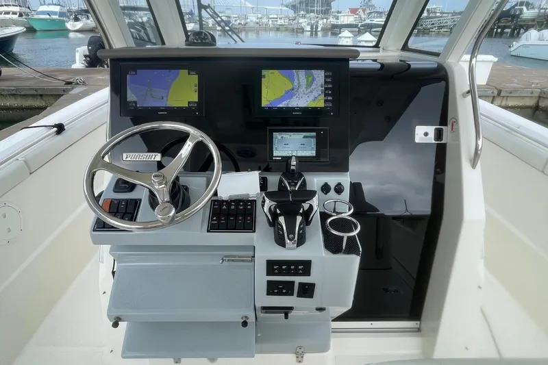 Slide: The Image of 2021 Pursuit S 328 Sport boat helm with dual navigation screens and steering wheel. - 20