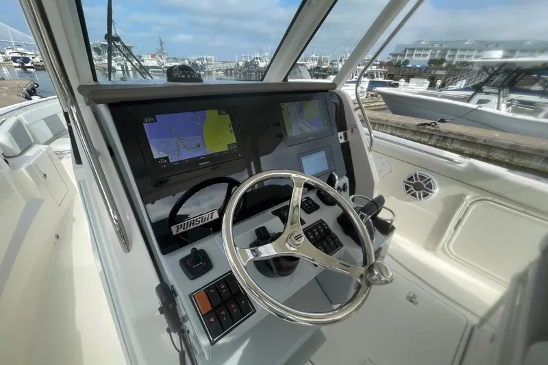 Slide: The Image of Helm of 2021 Pursuit S 328 Sport boat with navigation screens and steering wheel. - 21
