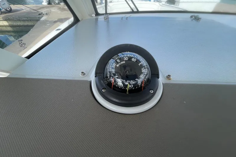 Slide: The Image of Compass on 2021 Pursuit S 328 Sport boat dashboard, dockside view. - 27