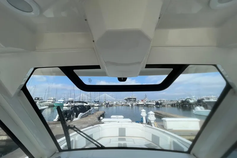 Slide: The Image of 2021 Pursuit S 328 Sport boat docked at marina, viewed from interior. - 29