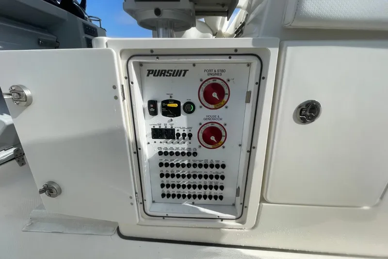 Slide: The Image of Control panel of a 2021 Pursuit S 328 Sport boat, featuring engine and generator switches. - 35