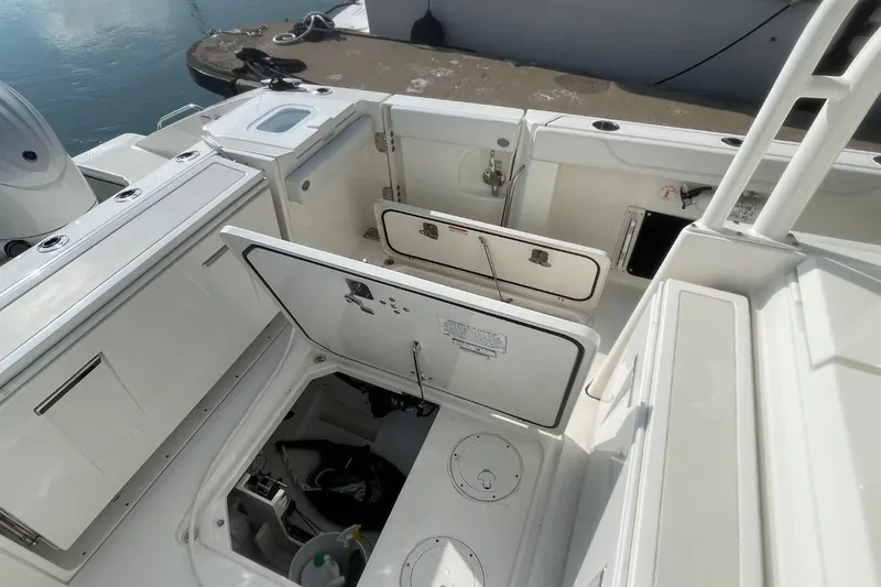 Slide: The Image of 2021 Pursuit S 328 Sport boat interior with open storage compartments at dock. - 38